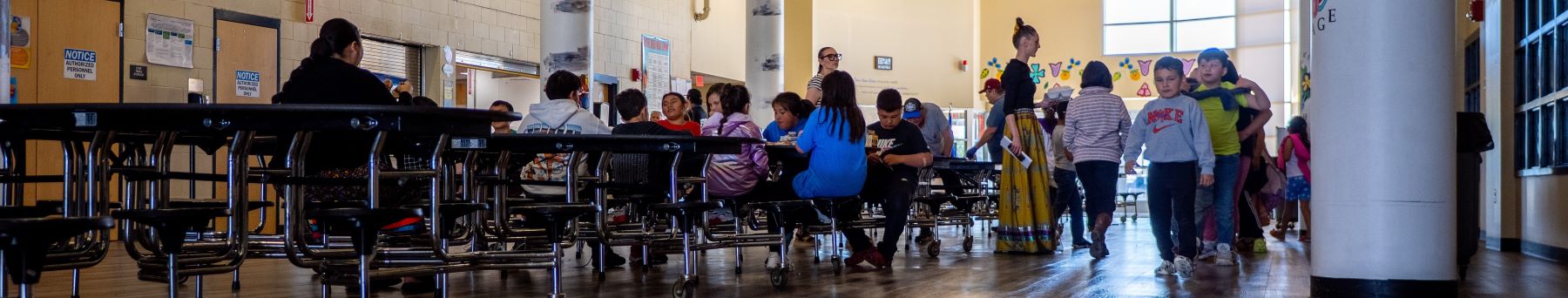 School cafeteria tables filled with students.
