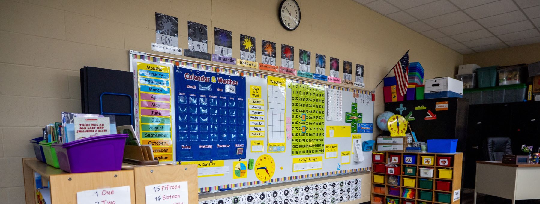 A vibrant classroom filled with colorful bulletin boards and a neatly organized desk, creating an inviting learning space.