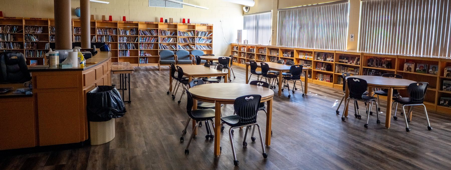 A spacious library featuring tables and chairs arranged for reading and studying.