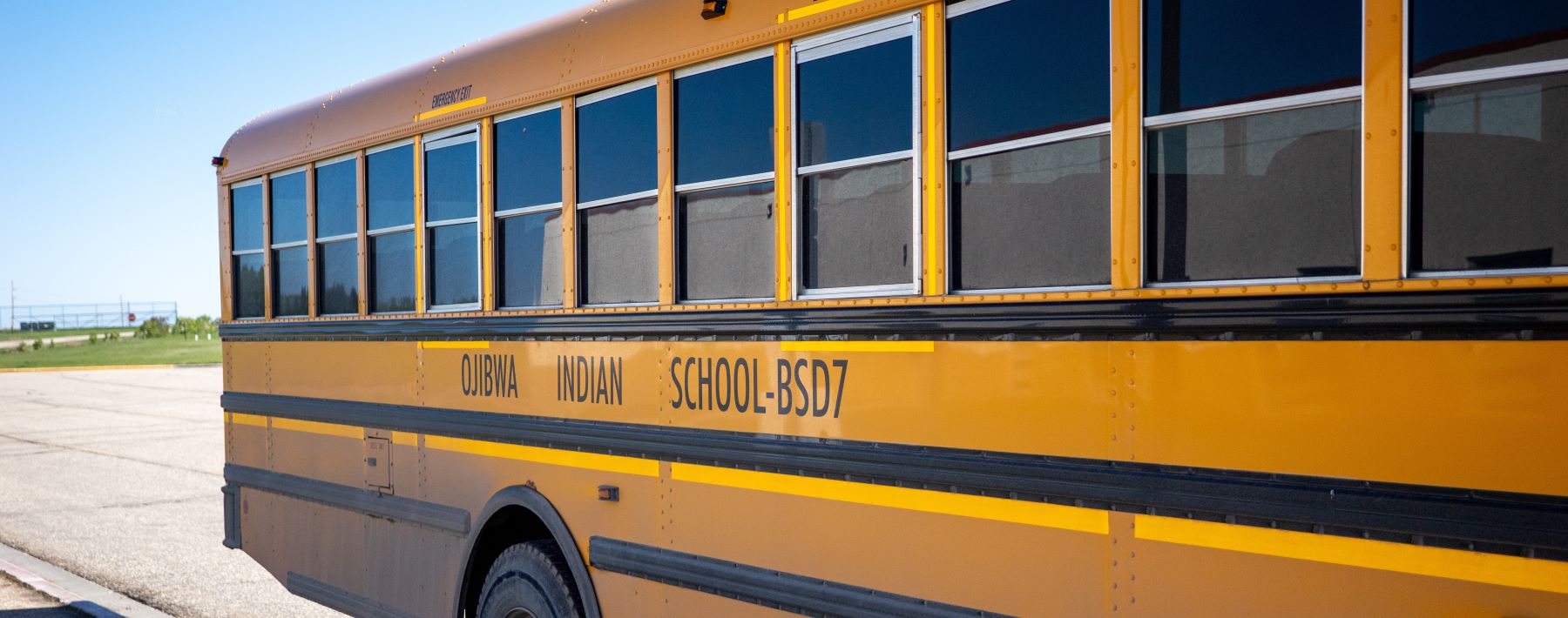 A yellow school bus parked on the side of the road, ready to pick up students.